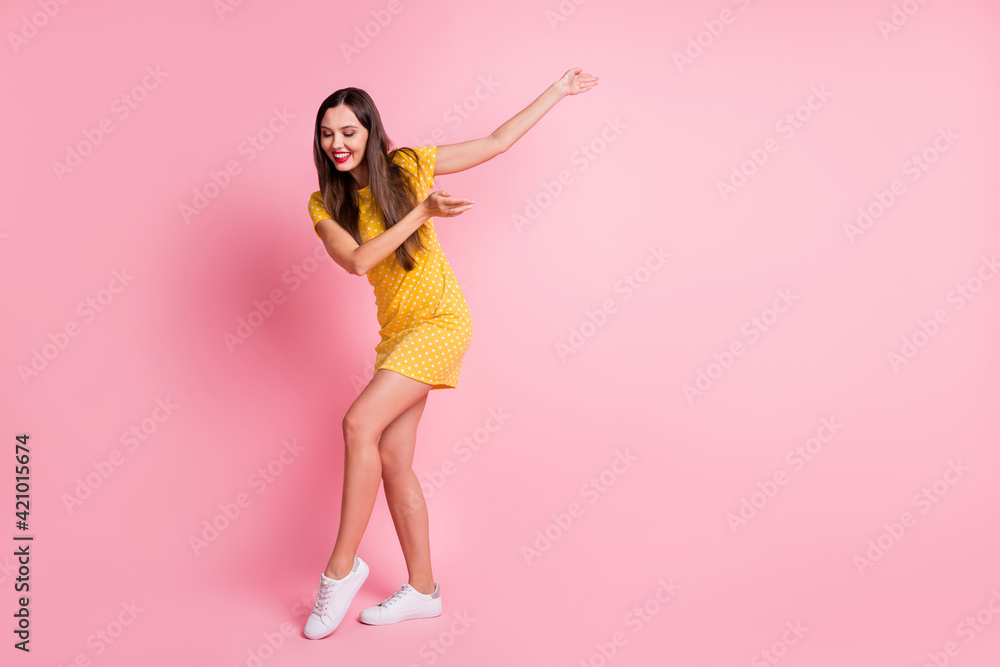 Full length photo of cheerful pretty young woman stand copyspace dance good mood isolated on pink color background Full length photo of cheerful pretty young woman stand copyspace dance good mood isolated on pink color background