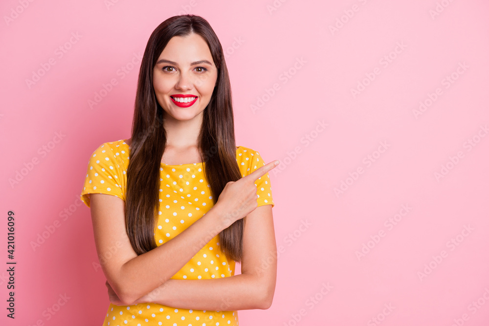 Photo of attractive young woman stand point finger empty space nice smile isolated on pink color background Photo of attractive young woman stand point finger empty space nice smile isolated on pink color background