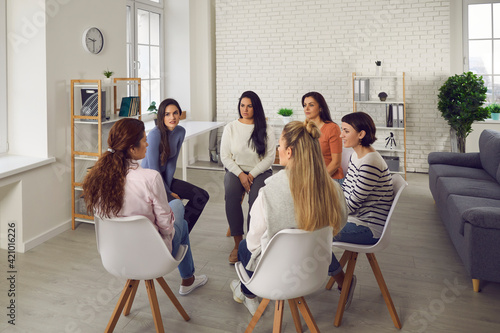 Young women telling their stories in therapy session or support group meeting. Female team talking, sharing news, discussing life situations, giving each other advice, working out solutions together