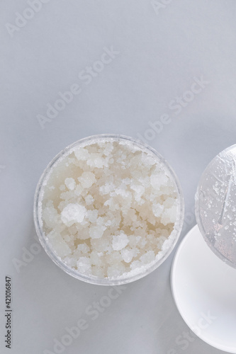 Face Skin Scrub sample and container with scrub on light background.