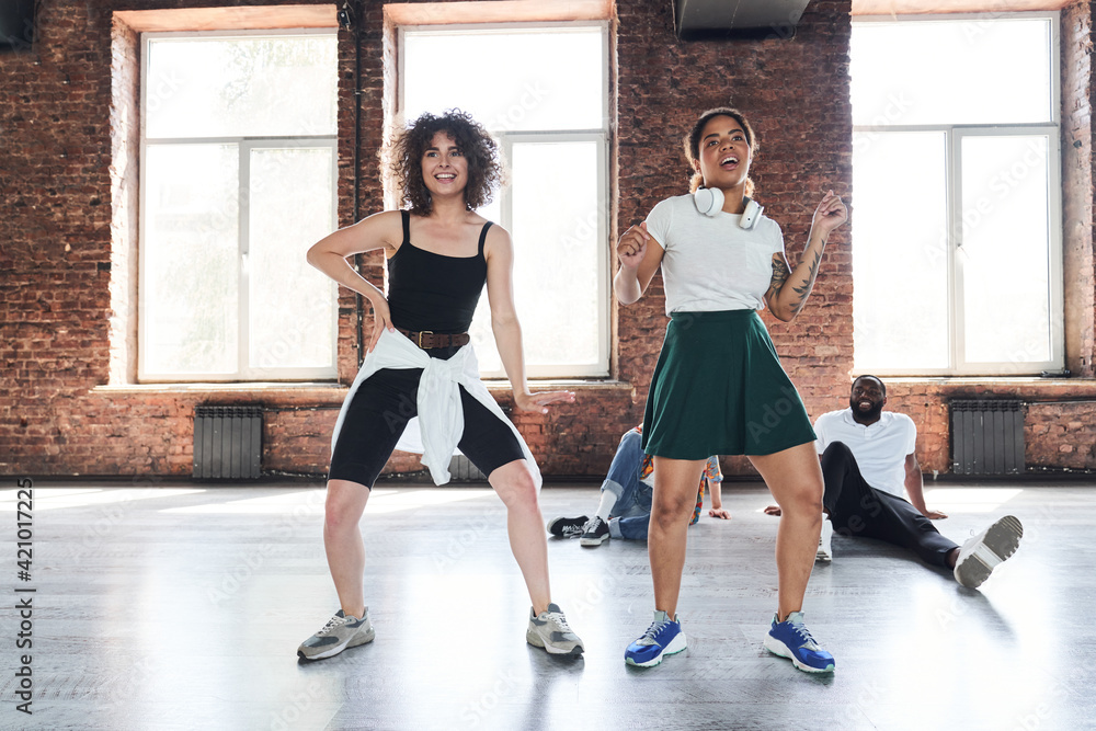 Happy women moving under hip-hop in studio Happy women moving under hip-hop in studio