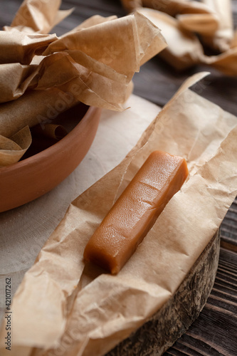 Wallpaper Mural Top view of handmade caramels wrapped in wax papers on dark board. Torontodigital.ca