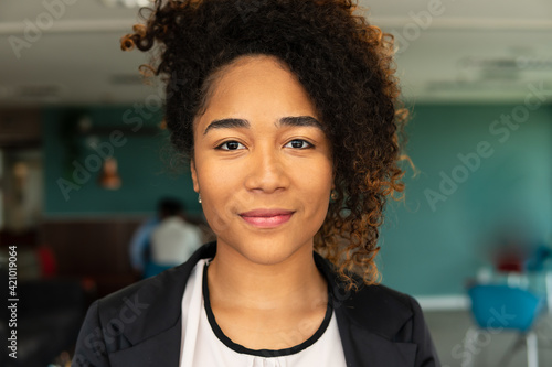 Portrait of black business woman looking at camera in the office. .