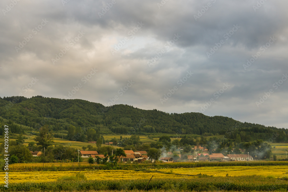 Fototapeta premium Villages and fields under dark clouds in autumn