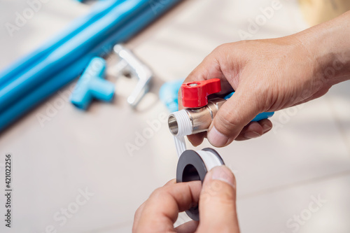 Photography plumber putting teflon thread tape on the thread , Preparing to connect to PVC P