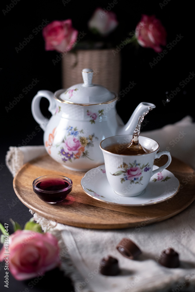 pouring hot steaming tea from a vintage teapot into glass cups