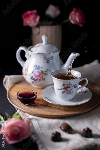 pouring hot steaming tea from a vintage teapot into glass cups