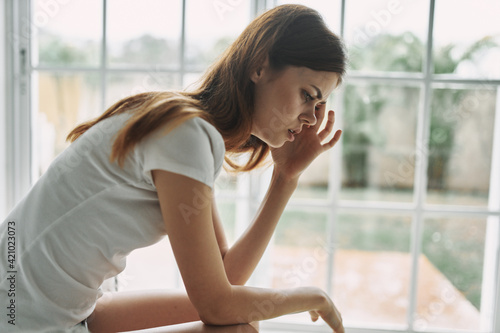 sad woman in a white t-shirt touches her face with her hands Free Download sad woman in a white t-shirt touches her face with her hands - GFXLoad