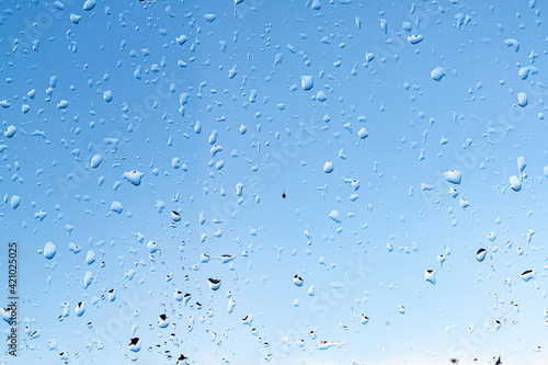 Raindrops on the window against the blue sky.