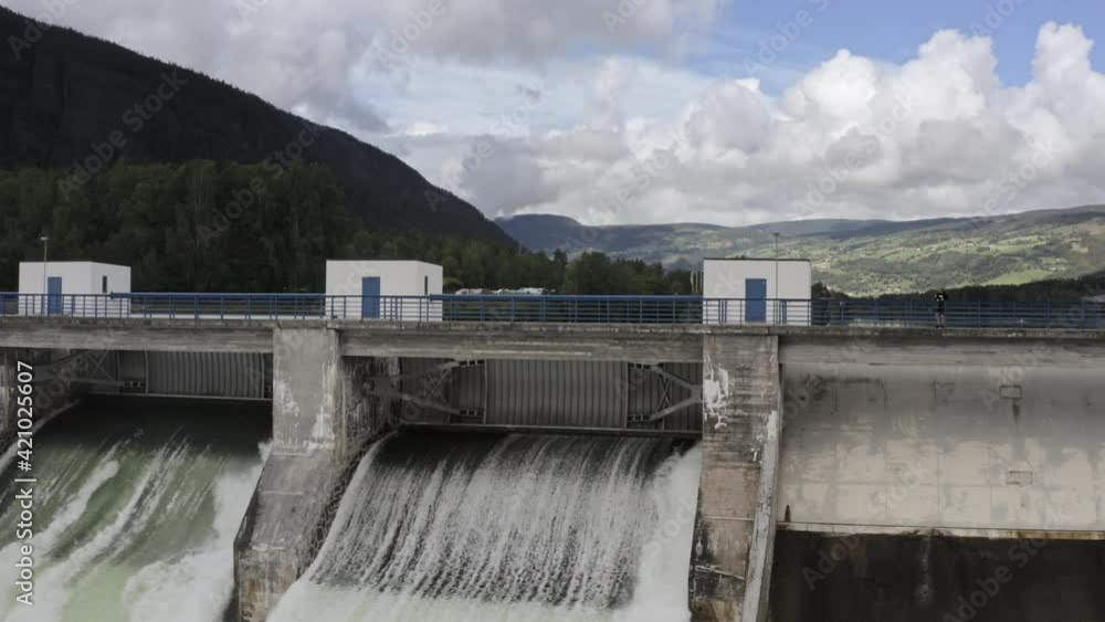 Man Watching Water Flowing Through Hydroelectric Dam Man Watching Water Flowing Through Hydroelectric Dam