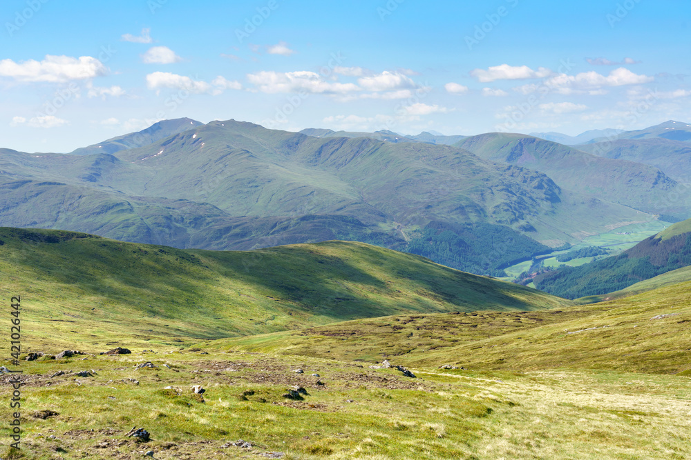 Distant views of the mountain summits of Meall Garbh, Ben Lawers, Beinn Ghlas and Meall Corranaich from below the top of Carn Mairg with Glen Lyon below in the Scottish Highlands, UK landscapes.