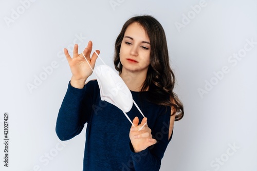 beautiful young woman wearing an anti viurs protection ffp2-mask to prevent from corona covid-19 and sars cov 2 infection white background copy space photo