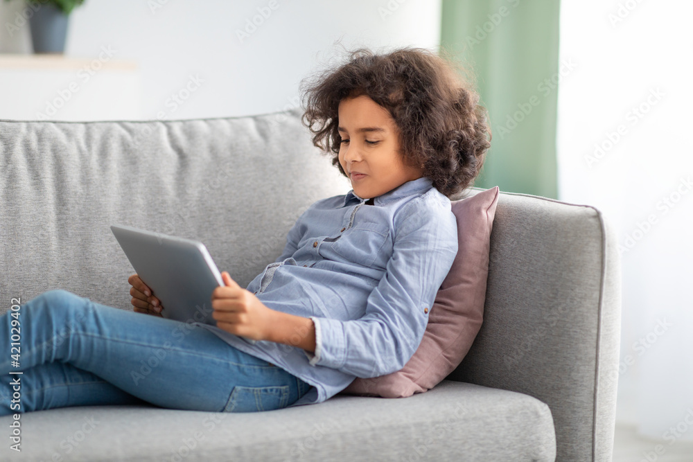 Black girl using digital tablet, lying on the couch Black girl using digital tablet, lying on the couch