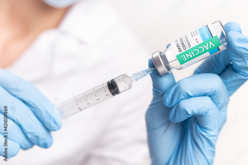 SARS - CoV2 Vaccination concept. Close up COVID-19 vaccine dose. A doctor or nurse in a laboratory holds a vial with a vaccine. Pandemic immunity SARS - CoV2 Vaccination concept. Close up COVID-19 vaccine dose. A doctor or nurse in a laboratory holds a vial with a vaccine. Pandemic immunity