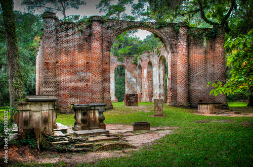 red brick skeleton of the Old Sheldon Church Ruins in Beaufort County, South Carolina with Spanish moss hanging from the surrounding trees photo