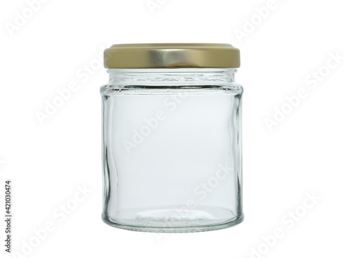 Empty glass jar, covered with a gold-colored metal lid. Isolated on a white background