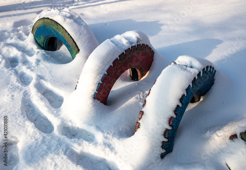 Old rubber car tires in the snow in winter.