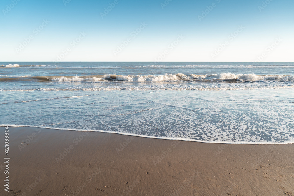 Small waves on sand at the seashore