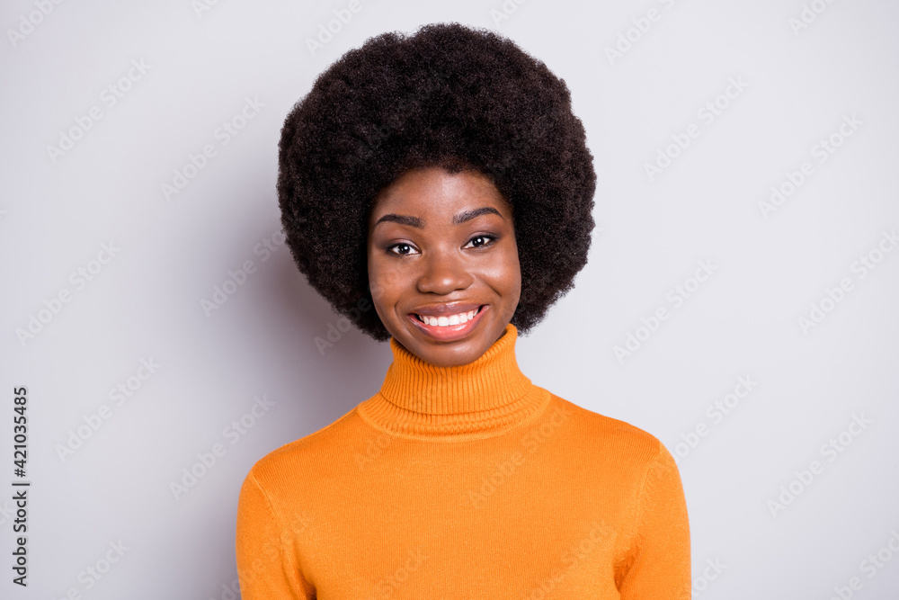 Photo of adorable curly hairstyle dark skin lady smile look camera wear roll neck outfit isolated on grey color background Photo of adorable curly hairstyle dark skin lady smile look camera wear roll neck outfit isolated on grey color background