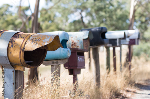 row old letterbox mail grass bush rustic rural farm grass outback recycled reuse australia reuse repurpose