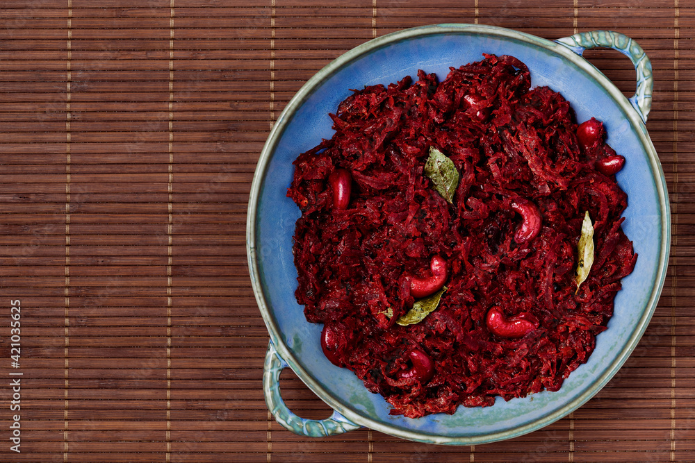 Beetroot curry made from grated beetroot with coconut milk, grated coconut and cashews. Indian cuisine meal in plate placed on black slate. Top view. Beetroot curry made from grated beetroot with coconut milk, grated coconut and cashews. Indian cuisine meal in plate placed on black slate. Top view.