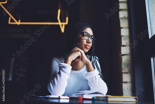 Φωτογραφία Concentrated African American woman looking out window