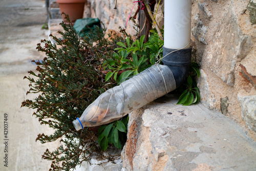 Canvas Print Reuse of an old plastic bottle to lengthen downspout close up