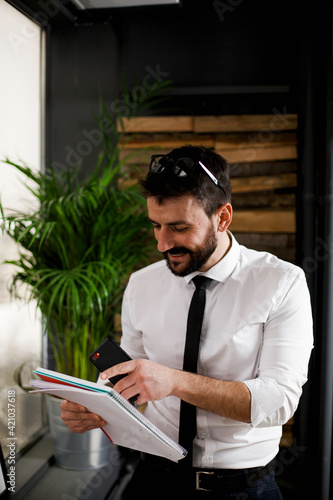 Businessman in office using the phone. Young man typing a message.