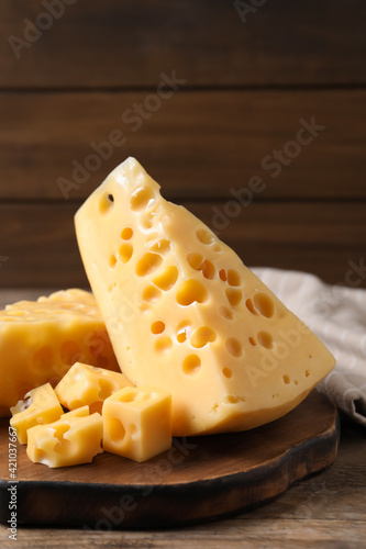 Pieces of delicious cheese on wooden table, closeup