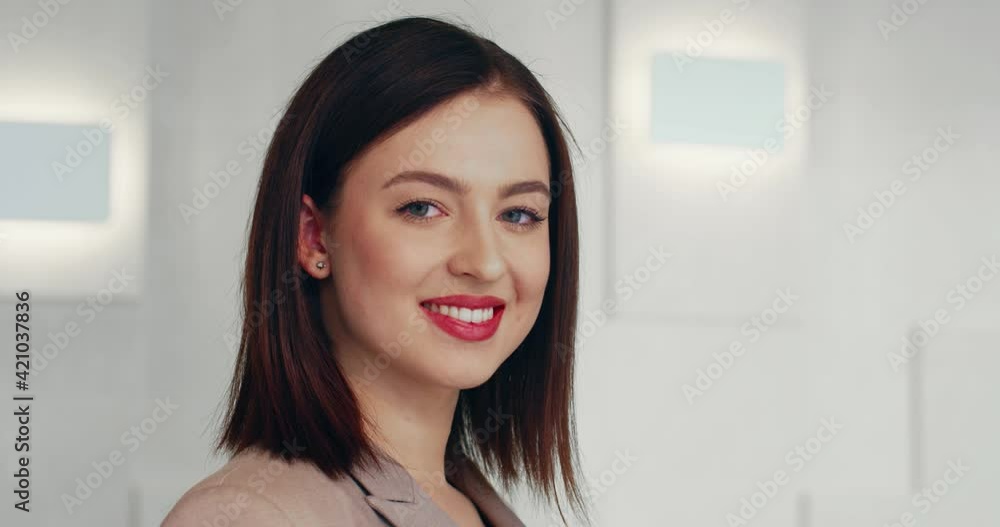 Close up portrait of young beautiful business woman in gray suit standing and looking at camera smiling. Close up portrait of young beautiful business woman in gray suit standing and looking at camera smiling.