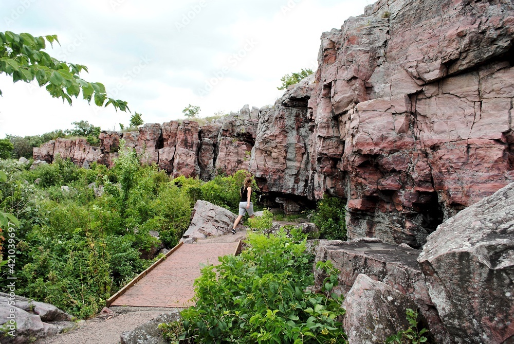 Hiker on trail in Pipestone National Monument, located in southwestern Minnesota. The catlinite, or pipestone from here, has been traditionally used to make traditional Plains Indian ceremonial pipes.