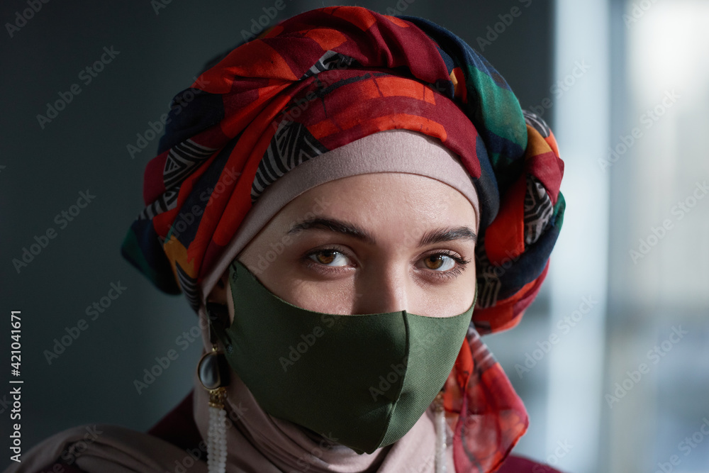 Portrait of muslim woman in beautiful scarf on her head and protective mask looking at camera
