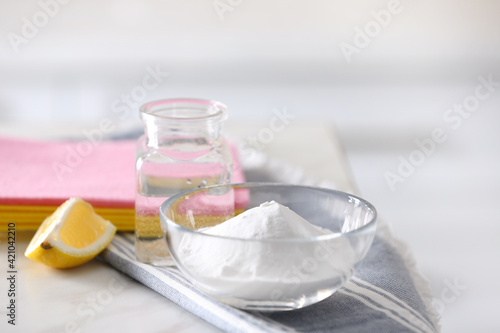 Baking soda, lemon and vinegar on white marble table. Eco friendly detergents