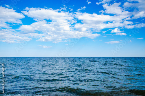 Seascape background wavy blue sea and sky with clouds © Annuitti