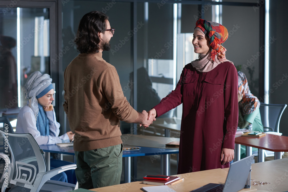 Obraz premium Businessman shaking hand to muslim businesswoman before business meeting at office