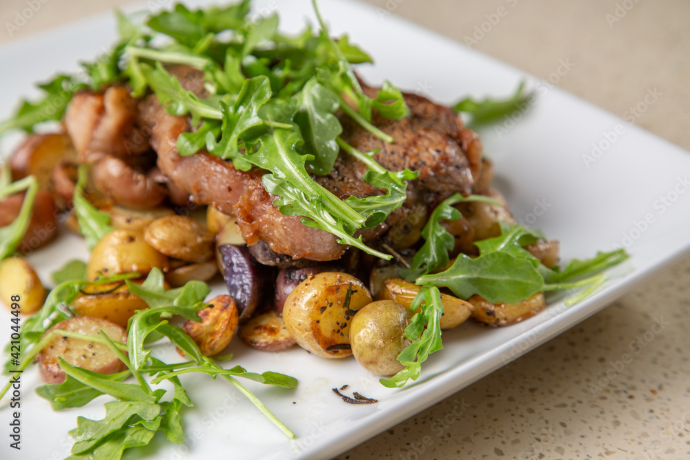 Rib eye steak with cut potatoes in green salad 