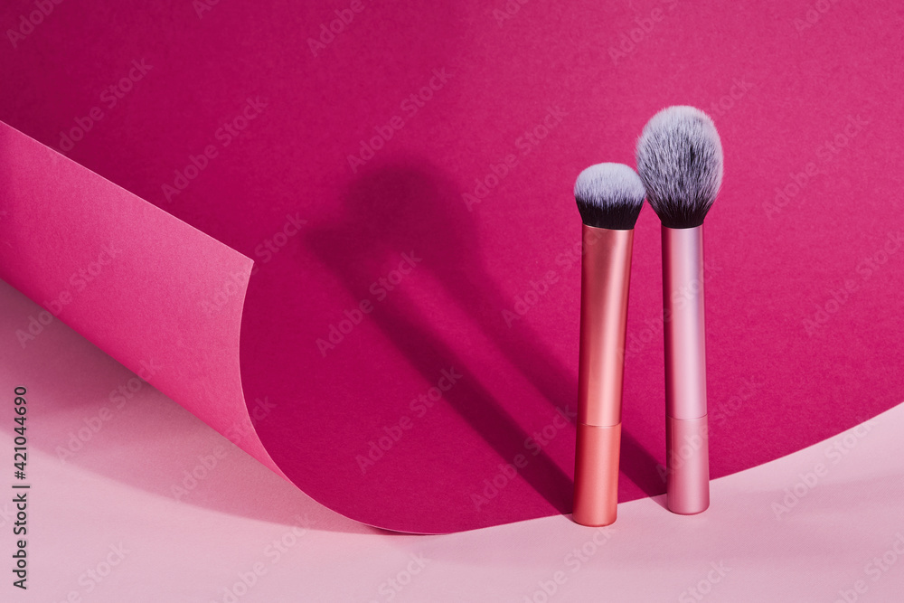 Makeup brushes on pink and burgundy paper background. Cosmetic professional Make up Brushes Makeup brushes on pink and burgundy paper background. Cosmetic professional Make up Brushes