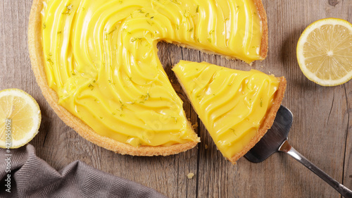 Fotografia lemon tart and slice on wood background