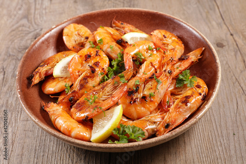 grilled shrimp and spices on wood background