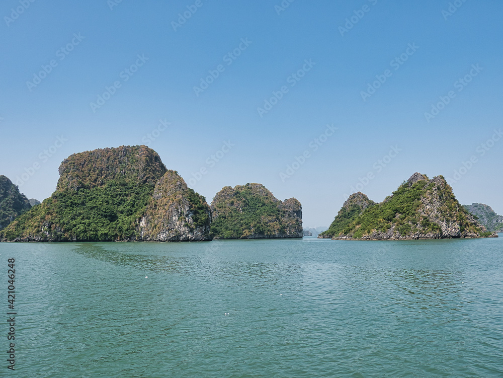 Naklejka premium The Ha Long Bay (Vietnam) in the Gulf of Tonkin with limestone karst and islands of various shapes and sizes on a cloudless day