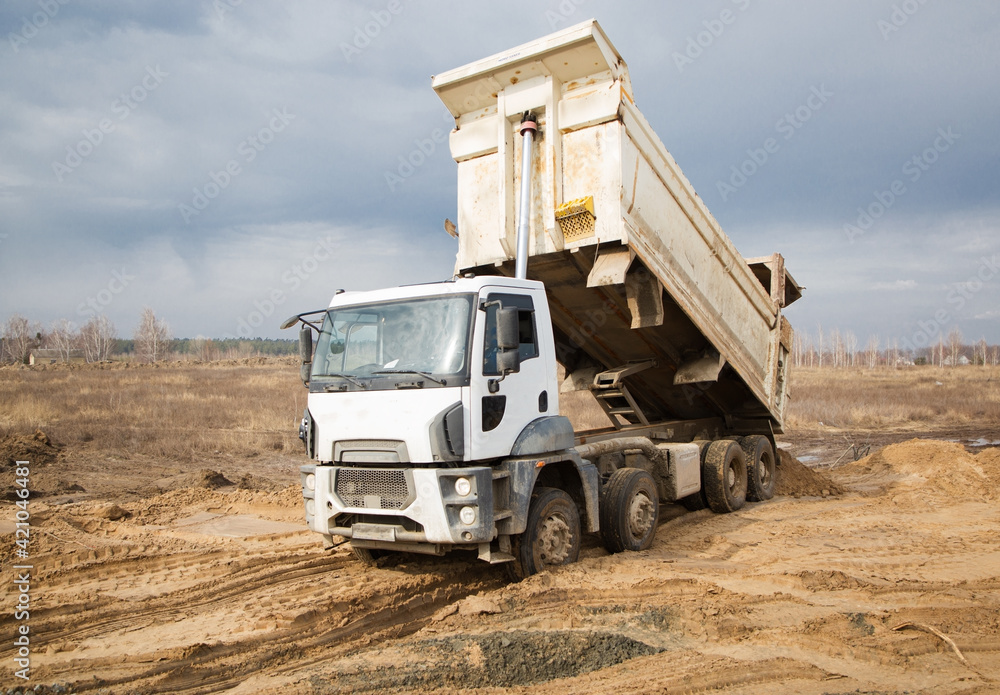 dump truck performs earthwork at a construction site. Unloading the soil. Preparatory work on construction dump truck performs earthwork at a construction site. Unloading the soil. Preparatory work on construction