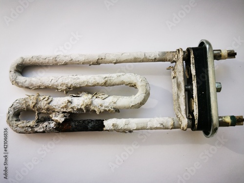 Breaking petn of the washing machine. Heater or tubular electric and scum requires replacing the heating element. Close-up photo on a white background
 photo