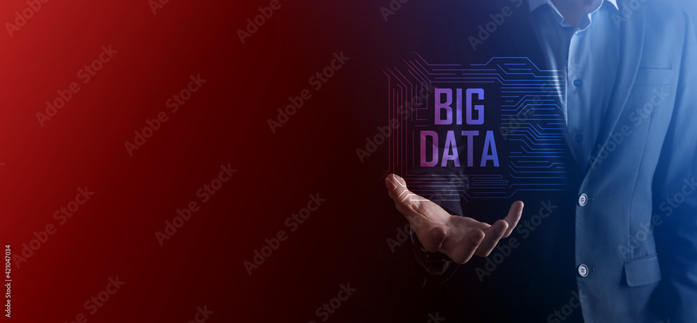 Businessman in a suit on a dark background holds the inscription BIG DATA. Storage Network Online Server Concept.Social network or business analytics representation Businessman in a suit on a dark background holds the inscription BIG DATA. Storage Network Online Server Concept.Social network or business analytics representation