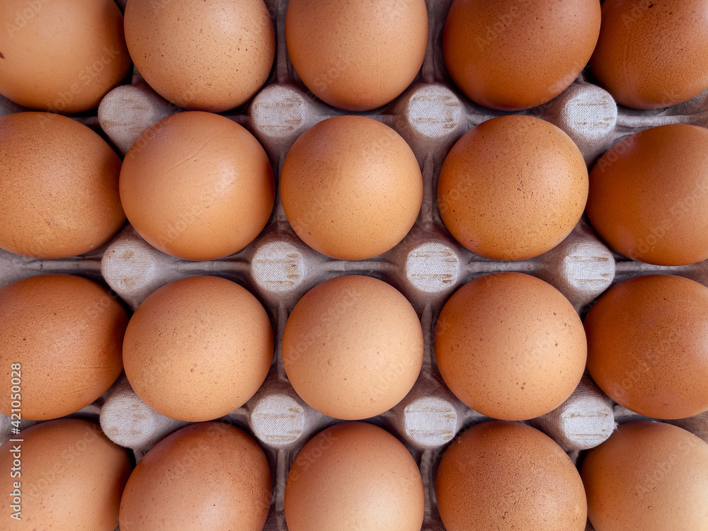 Brown eggs in cardboard egg box. Top view of raw organic chicken eggs in carton. Brown eggs in cardboard egg box. Top view of raw organic chicken eggs in carton.