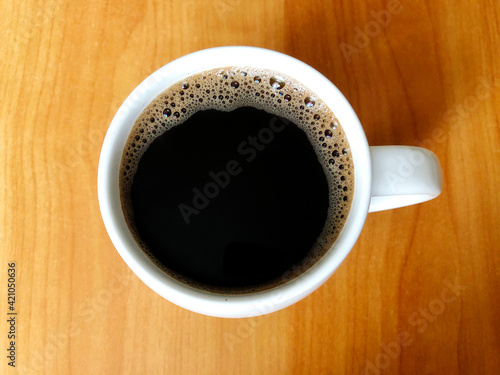 cup of coffee on wood table, coffee cup on grunge wooden table top background, coffe cup closeup 