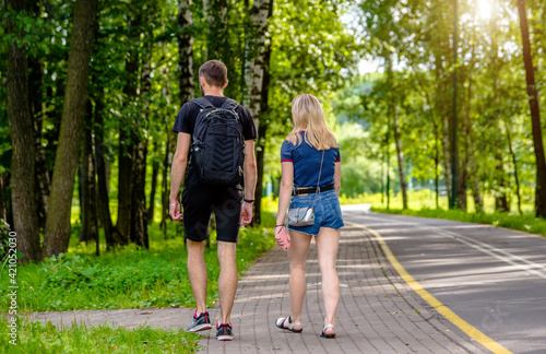 A guy and a girl walk along the path in the city Park 