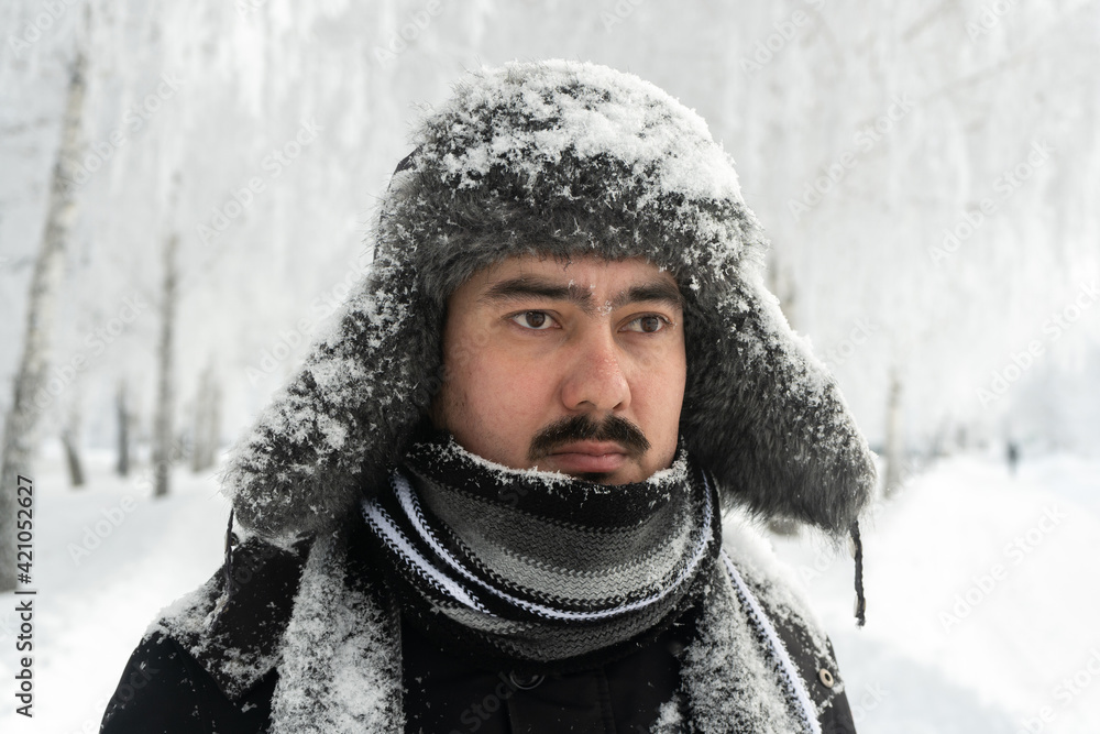 Formidable Russian man in a winter hat and scarf with a stern look Formidable Russian man in a winter hat and scarf with a stern look