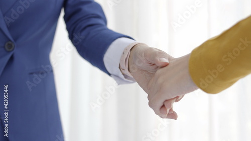 Hand shake between a businesswoman and a businesswoman, teamwork concept.
