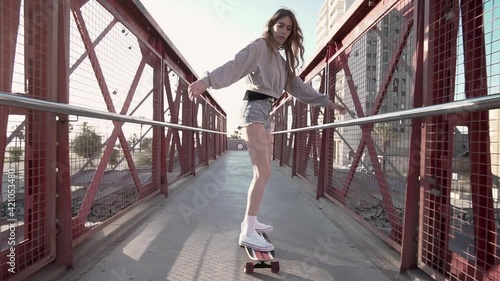 A young female skater with a skate surf board. Cool woman with a long board. California style.