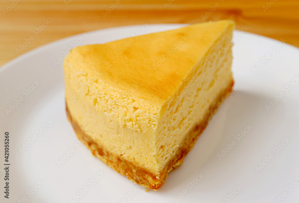 Closeup a slice of creamy baked cheesecake on a white plate Closeup a slice of creamy baked cheesecake on a white plate